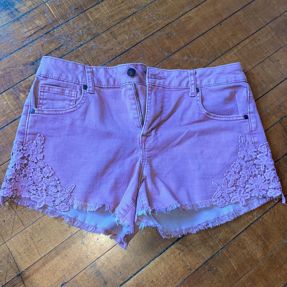 Stretchy mauve shorts with flower embroidery and fringe hem